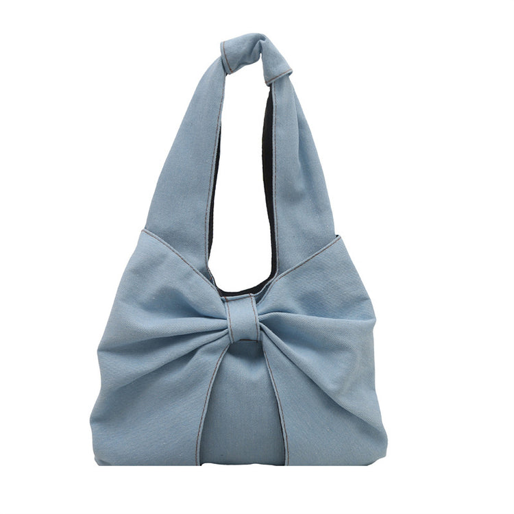 Light Blue denim bow shoulder bag with oversized bow, front view on a white background