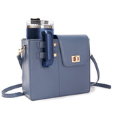 Blue STAN Sack crossbody bag with side cup holder holding a tumbler, front view