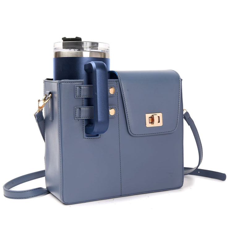 Blue STAN Sack crossbody bag with side cup holder holding a tumbler, front view