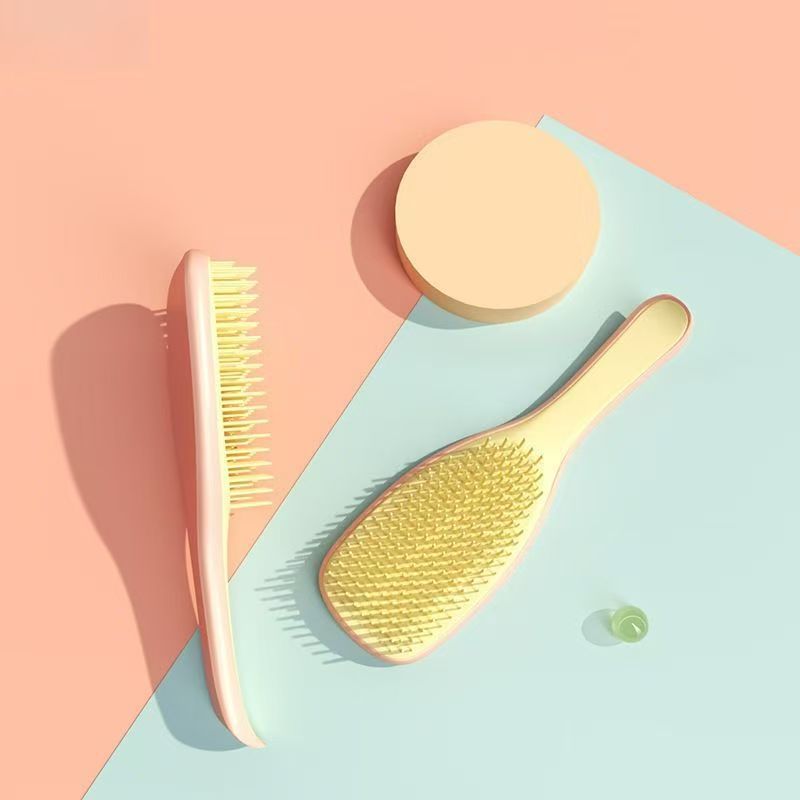 Peach Knotty Brush detangling hair brush on a peach and mint background