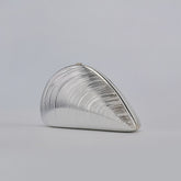 Silver ribbed shell acrylic clutch purse, side view on a light gray background