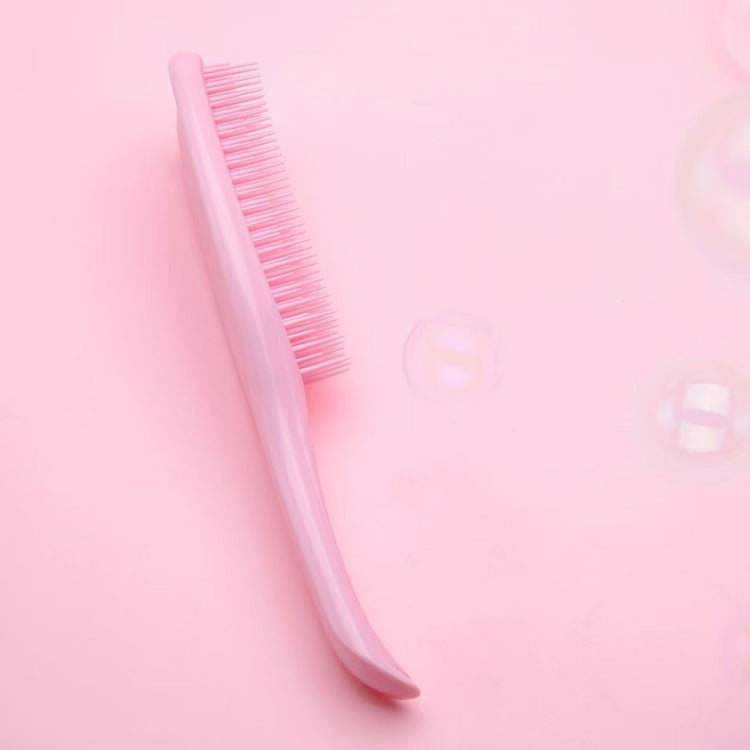 Pink Knotty Brush detangling hair brush with soft pink bristles on a pink background
