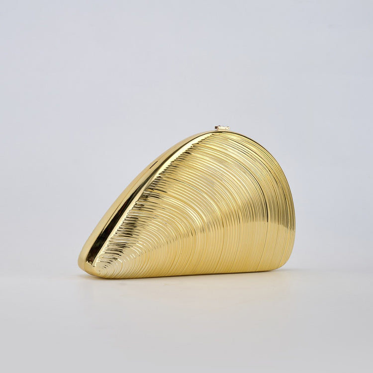 Gold ribbed shell acrylic clutch purse, side view on a light gray background